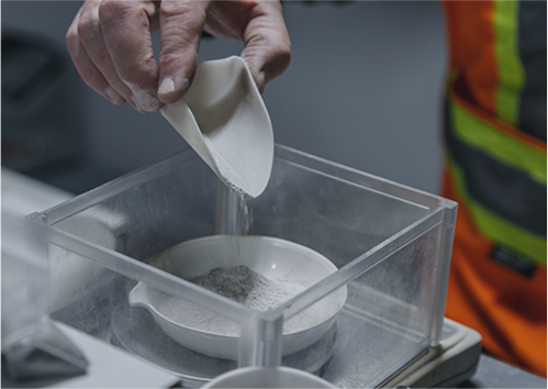 BarCan Lab Tech weighing the Barite concentrate produced in prep for being assayed: the final check on the product.